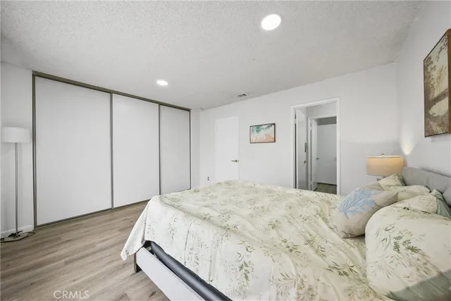 a bedroom with a large bed and wooden floor