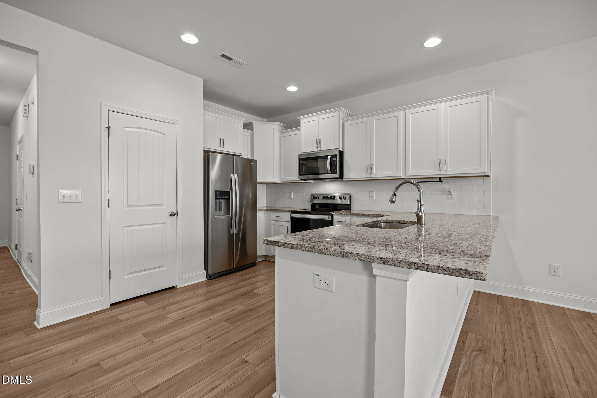 6173 Taylor Road Wendell, NC 27591 - Photo 3 of 31 a kitchen with stainless steel appliances granite countertop a refrigerator a sink a stove a microwave and white cabinets with wooden floor