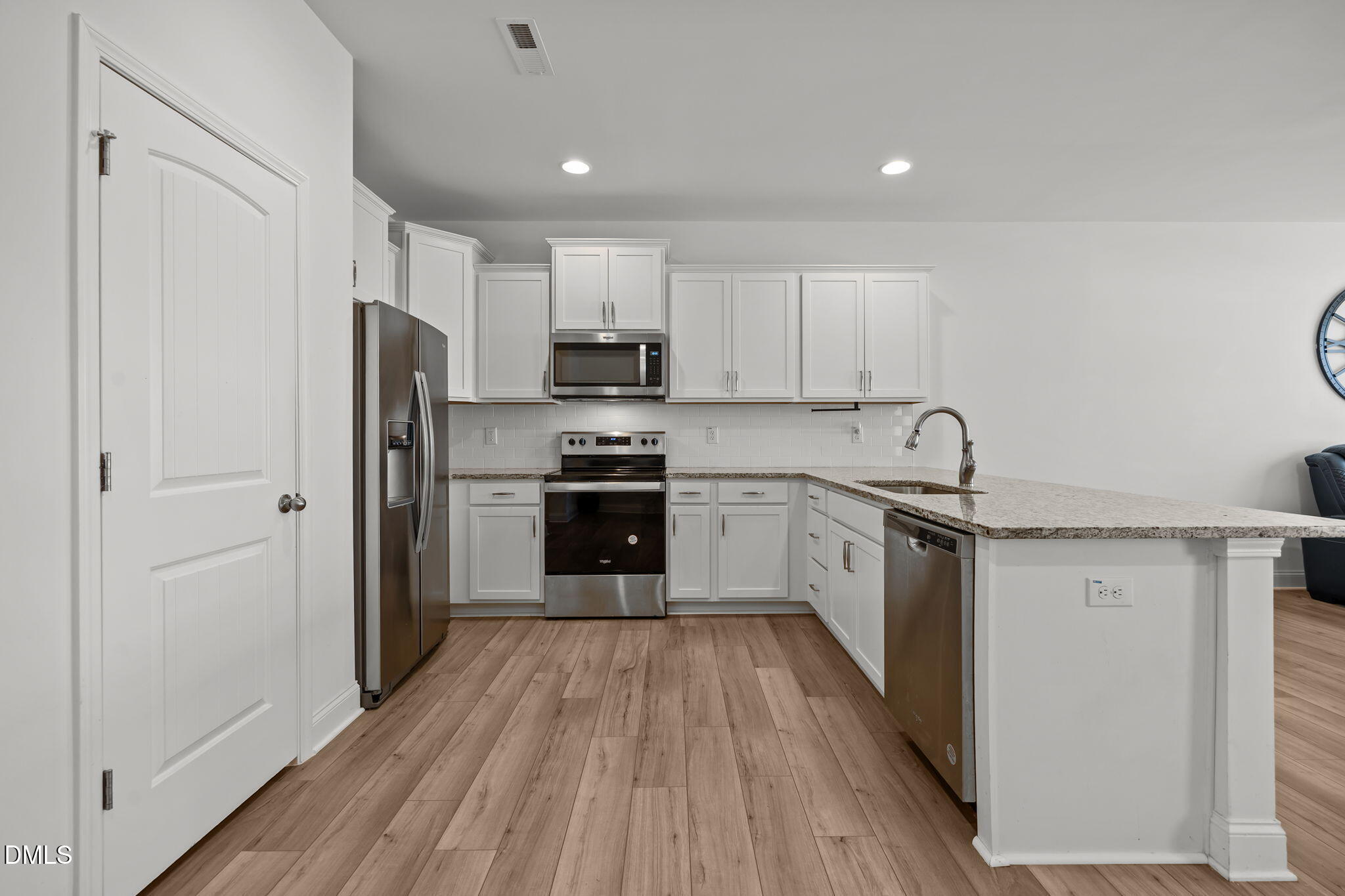 6173 Taylor Road Wendell, NC 27591 - Photo 4 of 31 a kitchen with a refrigerator a stove top oven a sink and dishwasher with wooden floor