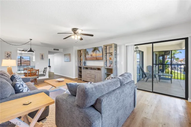 a living room with furniture and a ceiling fan