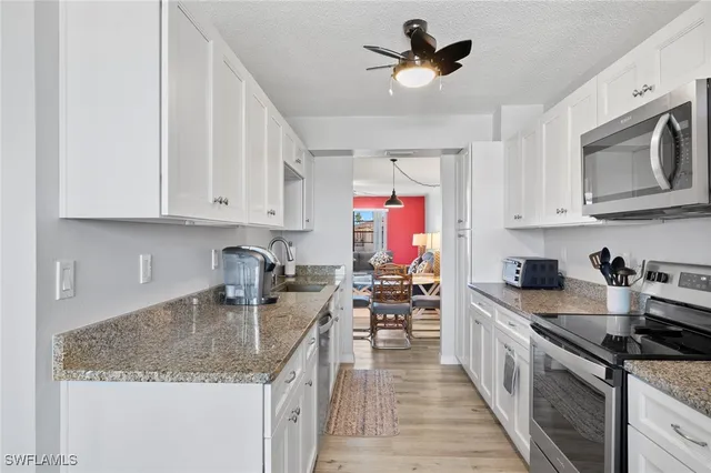 a kitchen with stainless steel appliances granite countertop a sink stove and cabinets