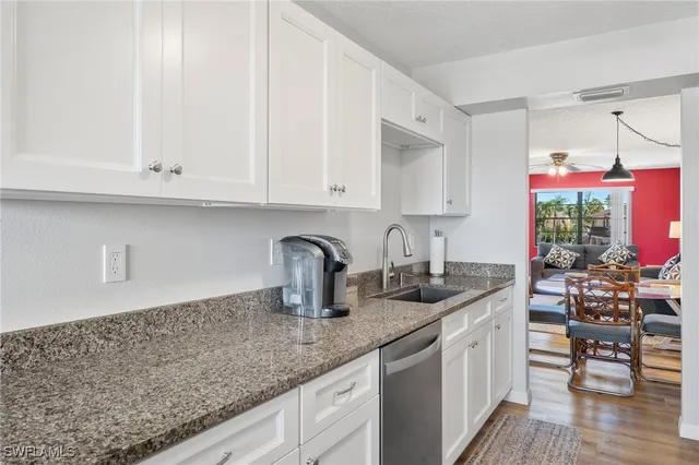 a kitchen with granite countertop a sink and cabinets