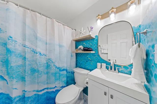 a bathroom with a sink a toilet and shower curtain