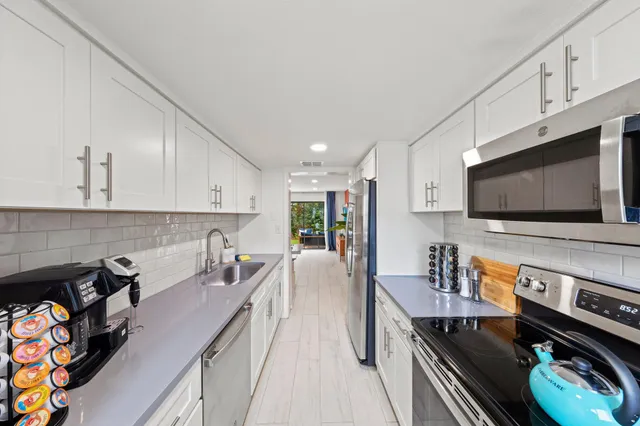 a kitchen with stainless steel appliances a stove a sink and a microwave