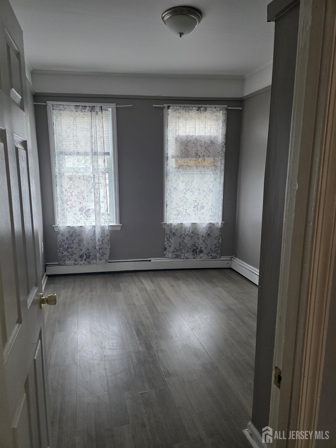 604 Freeman Street, Unit 2 Lyndhurst, NJ 07071 - Photo 6 of 8 an empty room with wooden floor and windows