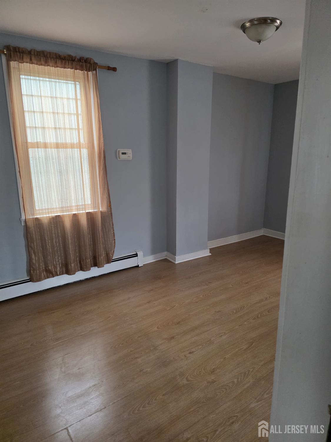 604 Freeman Street, Unit 2 Lyndhurst, NJ 07071 - Photo 7 of 8 an empty room with wooden floor and windows