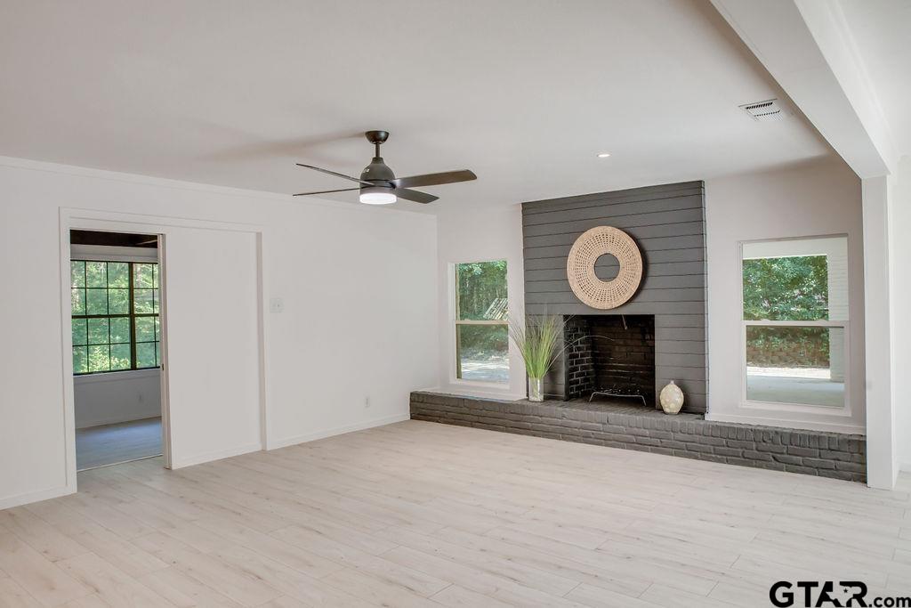 439 Lone Star Lane Hideaway, TX 75771 - Photo 14 of 36 an empty room with windows and a fireplace