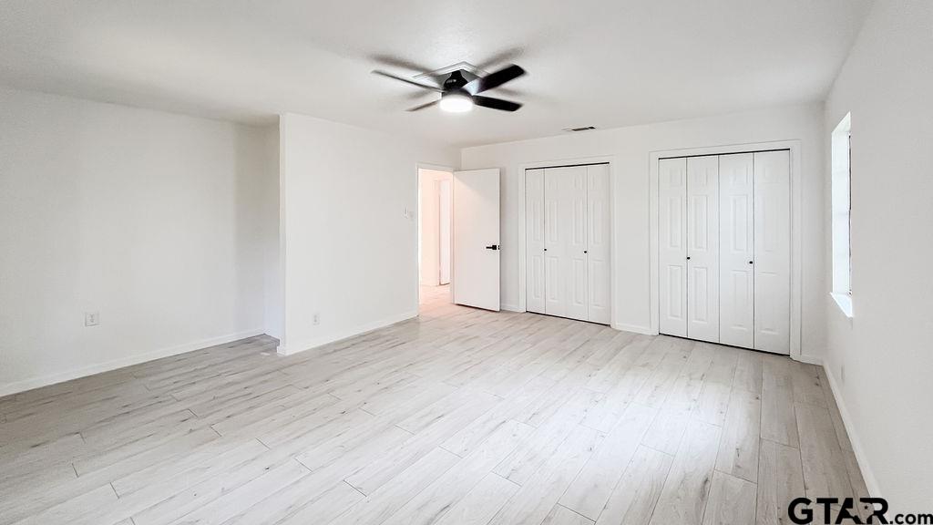 439 Lone Star Lane Hideaway, TX 75771 - Photo 31 of 36 an empty room with wooden floor ceiling fan and window