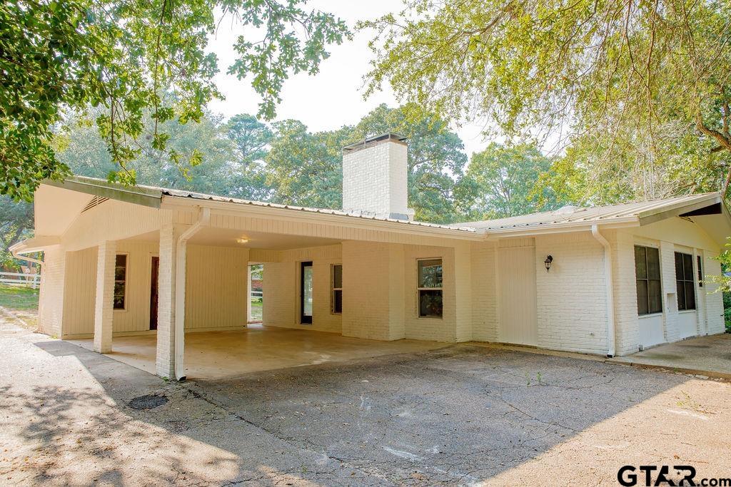 439 Lone Star Lane Hideaway, TX 75771 - Photo 4 of 36 a view of a white house with large windows and large tree