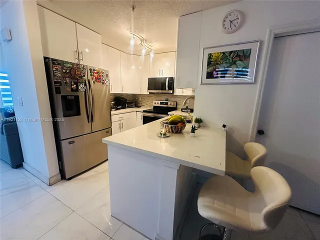 a kitchen with stainless steel appliances a refrigerator and a sink