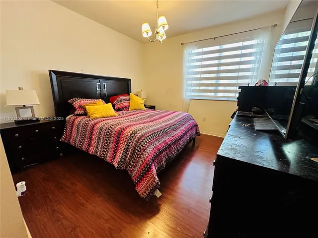 a bedroom with a bed a dresser and a window