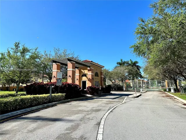 a backyard of a house with table and chairs potted plants and large tree