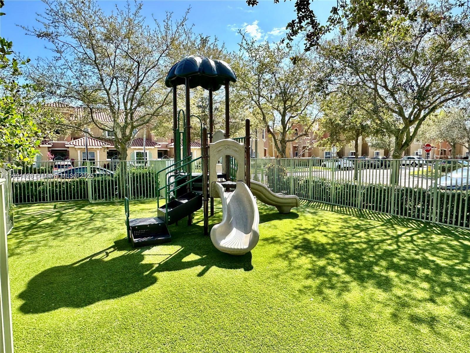 14343 Southwest 10th Street, Unit 2305 Pembroke Pines, FL 33027 - Photo 28 of 29 a backyard of a house with table and chairs potted plants and large tree