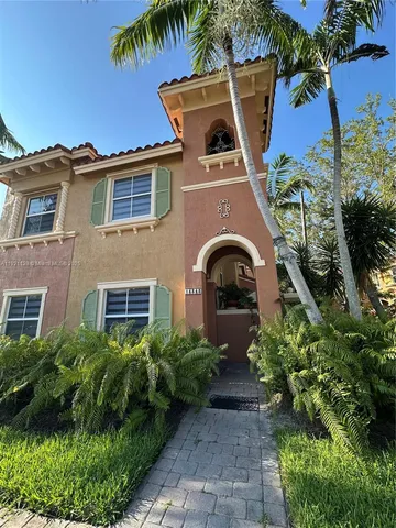 a front view of a house with a yard and potted plants