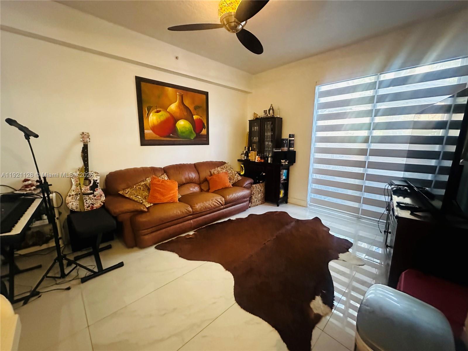 14343 Southwest 10th Street, Unit 2305 Pembroke Pines, FL 33027 - Photo 10 of 29 a living room with furniture and a flat screen tv