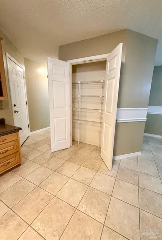 an empty room with windows and chandelier fan