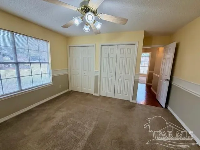 a bathroom with a granite countertop sink a mirror and a toilet