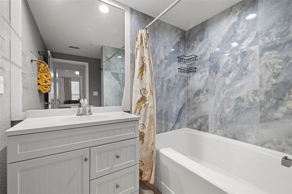2410 West Azeele Street, Unit 214 Tampa, FL 33609 - Photo 13 of 24 a bathroom with a sink a large mirror and a bathtub