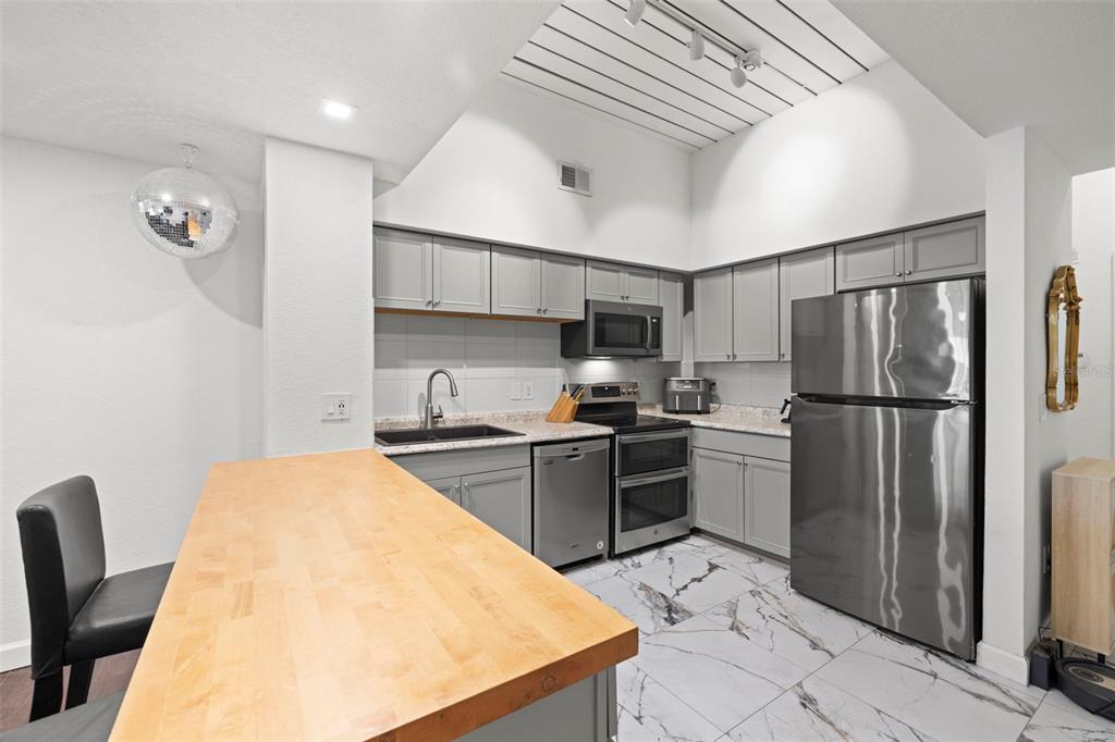 2410 West Azeele Street, Unit 214 Tampa, FL 33609 - Photo 4 of 24 a kitchen with stainless steel appliances granite countertop a refrigerator sink and stove