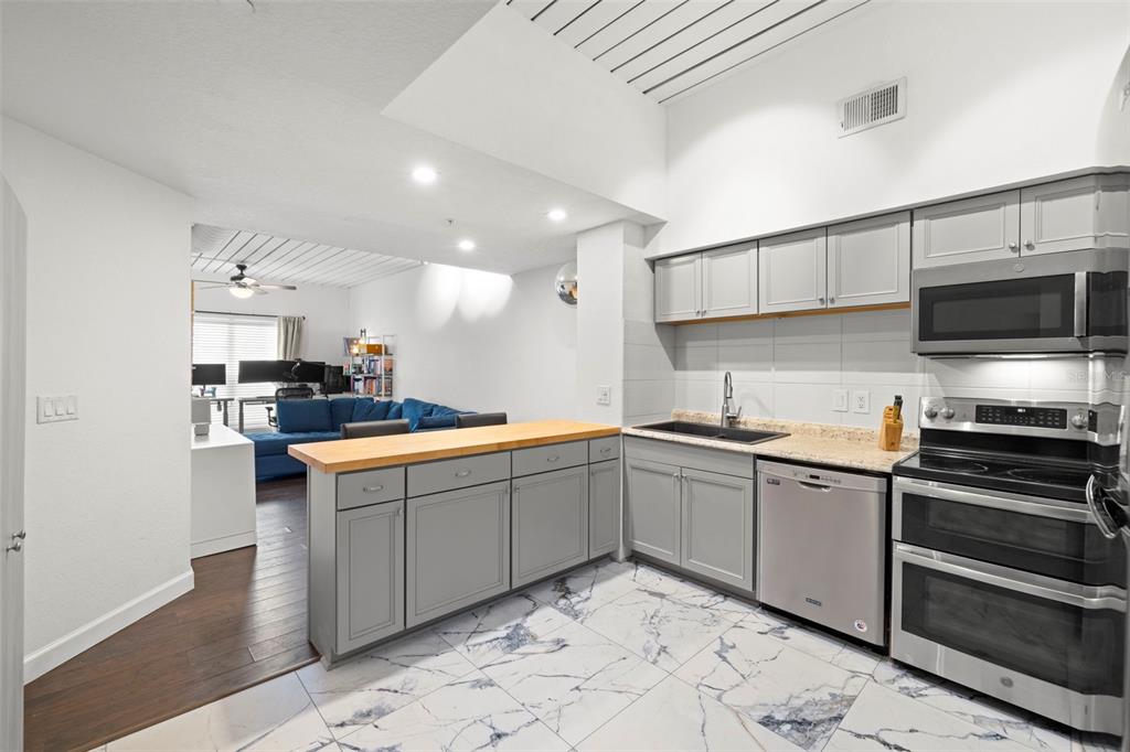 2410 West Azeele Street, Unit 214 Tampa, FL 33609 - Photo 7 of 24 a kitchen with stainless steel appliances kitchen island granite countertop a sink and a stove