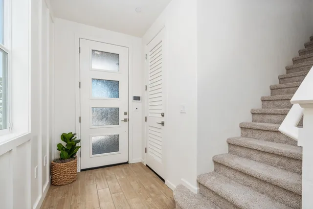 a view of an entryway with wooden floor and a living room