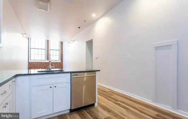 a kitchen with granite countertop white cabinets and white appliances