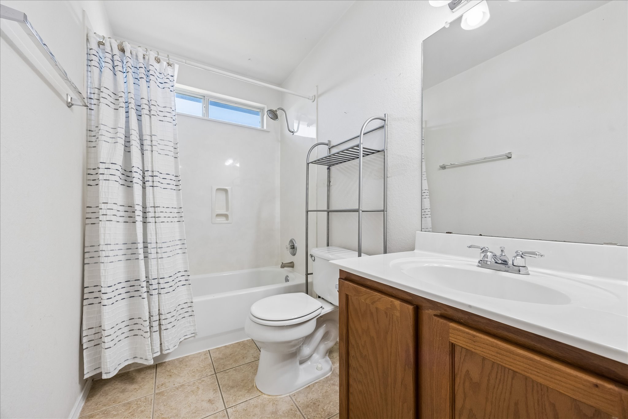 338 Spring Branch Loop Kyle, TX 78640 - Photo 24 of 36 A compact bathroom featuring a full bathtub with shower, a vanity, and essential fixtures.