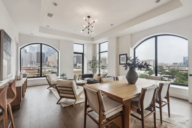 a dining room with furniture a chandelier and wooden floor