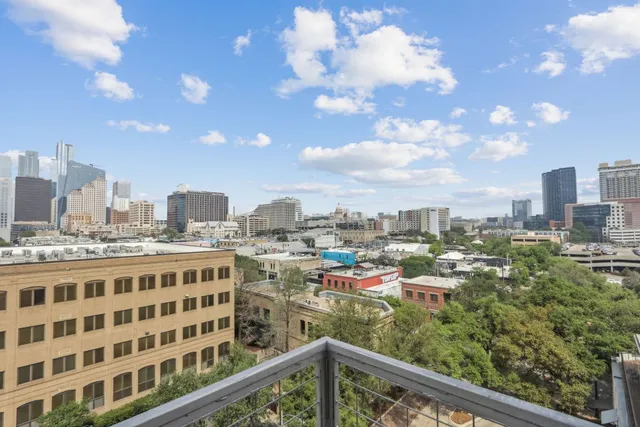 a view of balcony with a couple of cars parked in front of it