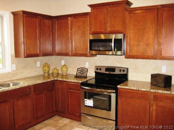 182 Culpepper Road Cameron, NC 28326 - Photo 8 of 13 a kitchen with stainless steel appliances granite countertop wooden cabinets a stove top oven a sink and dishwasher