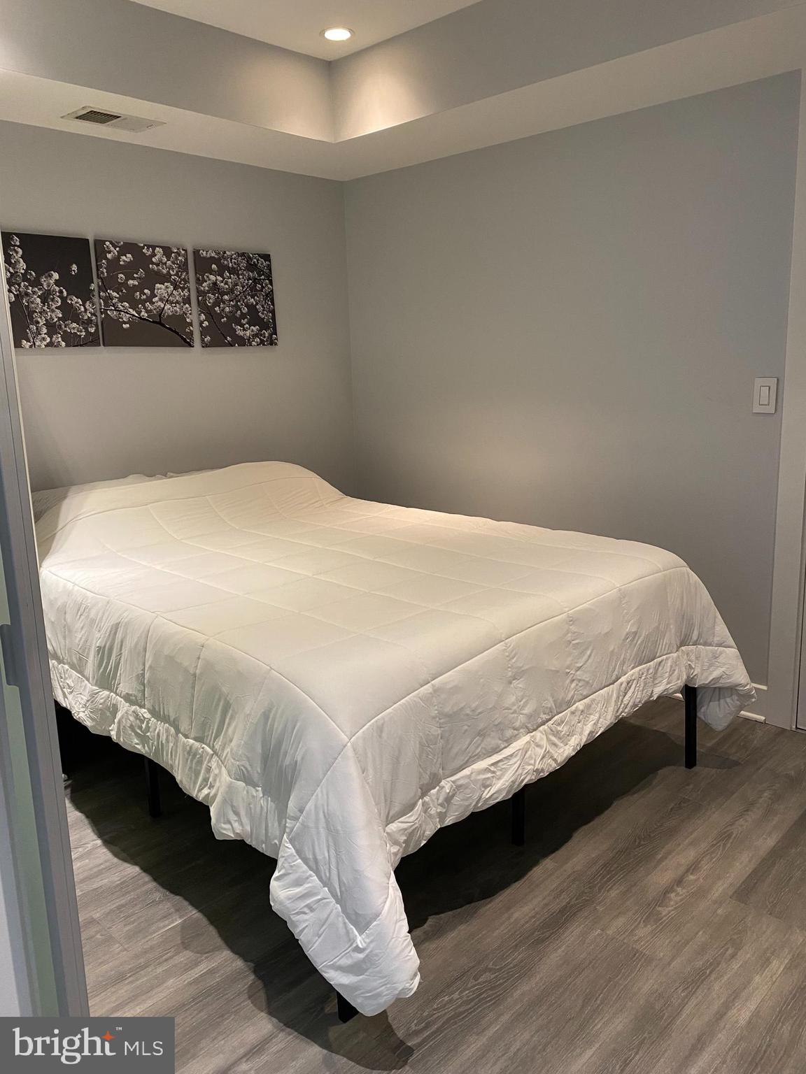 1209 G Street Southeast, Unit 2 Washington, DC 20003 - Photo 10 of 15 a bedroom with a bed and wooden floor