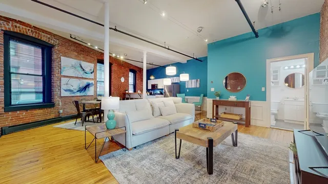 a living room with furniture wooden floor and a large window