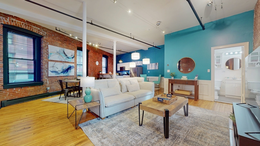 19 Stanhope Street, Unit 1A Boston, MA 02116 - Photo 1 of 21 a living room with furniture wooden floor and a large window