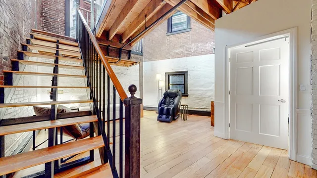 a view of entryway and hall with wooden floor