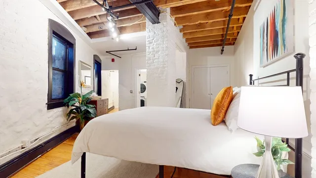 a bedroom with a bed and a potted plant