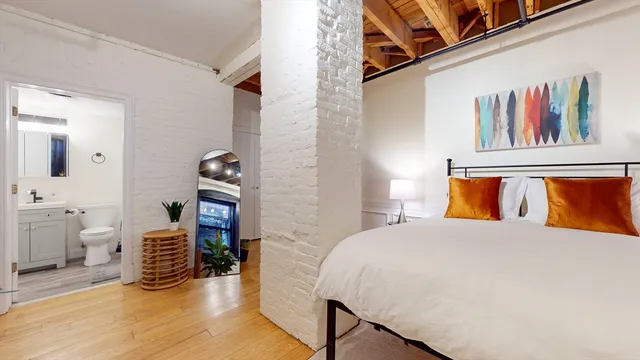 a bedroom with a bed and wooden floor