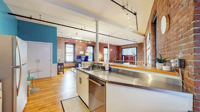 a kitchen with stainless steel appliances granite countertop a sink and a refrigerator