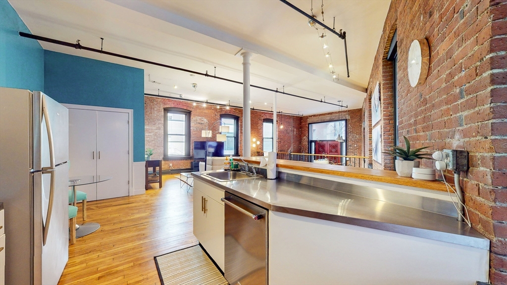 19 Stanhope Street, Unit 1A Boston, MA 02116 - Photo 8 of 21 a kitchen with stainless steel appliances granite countertop a sink and a refrigerator