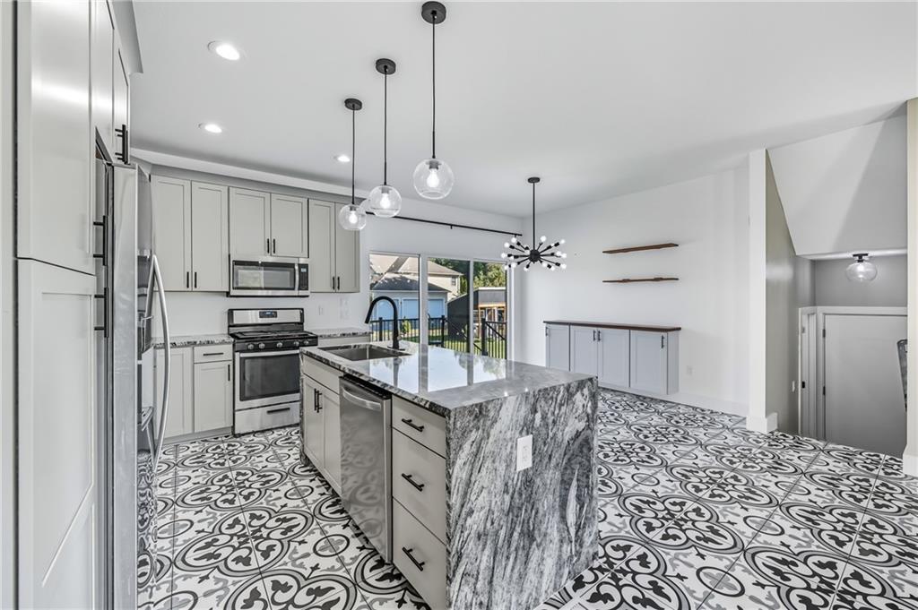 5237 Virginia Road Hermitage, PA 16148 - Photo 12 of 49 a kitchen with stainless steel appliances kitchen island granite countertop a refrigerator a stove and white cabinets with wooden floor