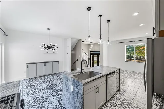 a kitchen with kitchen island granite countertop a sink a counter top space and cabinets