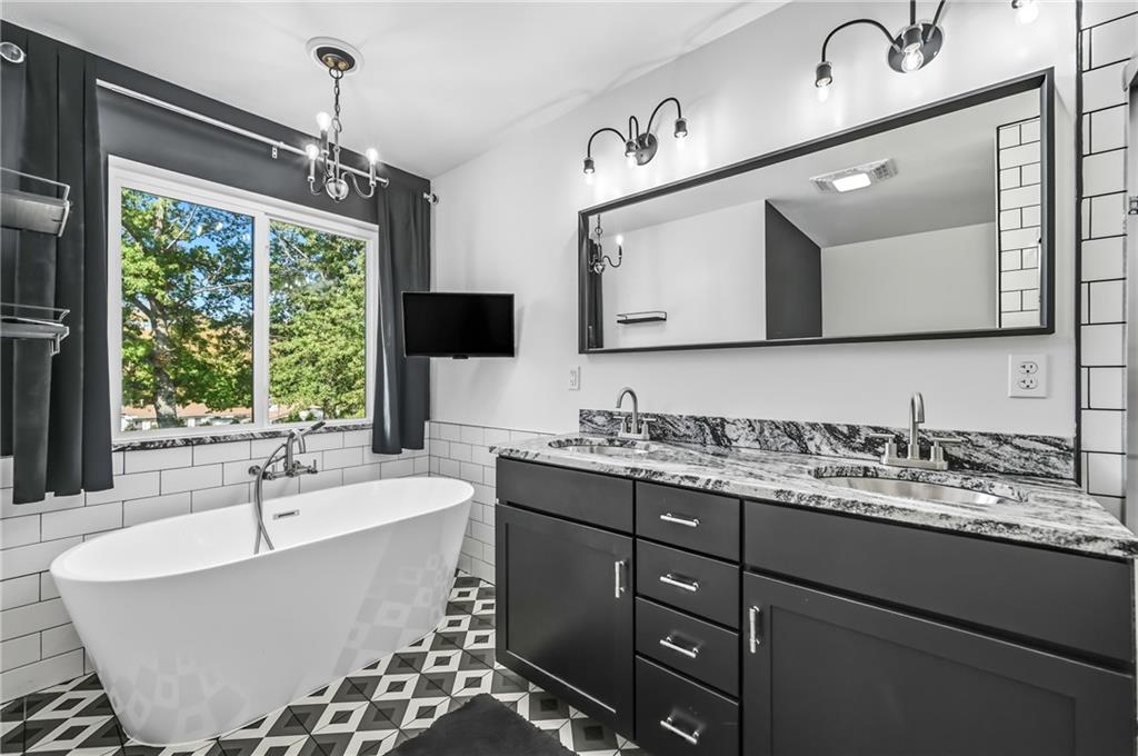 5237 Virginia Road Hermitage, PA 16148 - Photo 28 of 49 a bathroom with a double vanity sink a large mirror and a bathtub
