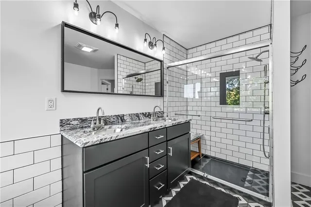 a bathroom with a shower sink and mirror