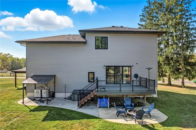 a patio with table and chairs and potted plants