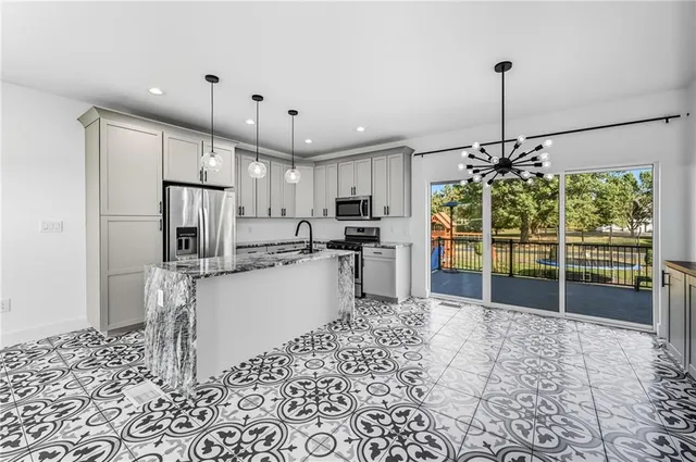 a kitchen with stainless steel appliances granite countertop a refrigerator and a sink