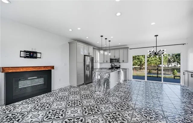 a kitchen with stainless steel appliances kitchen island granite countertop a refrigerator and a sink