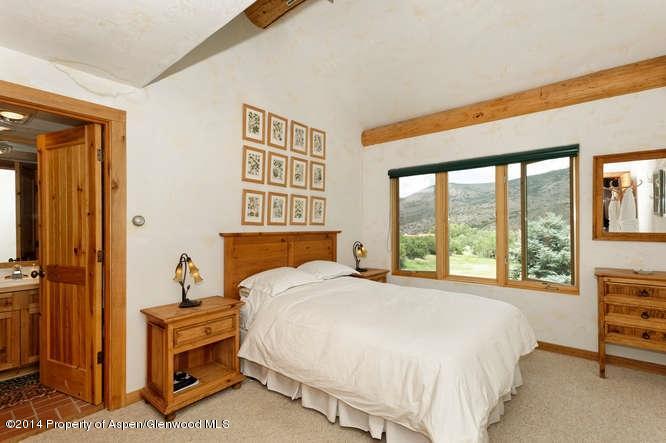 3768 Snowmass Creek Road Snowmass, CO 81654 - Photo 22 of 28 a bedroom with a bed and a large window