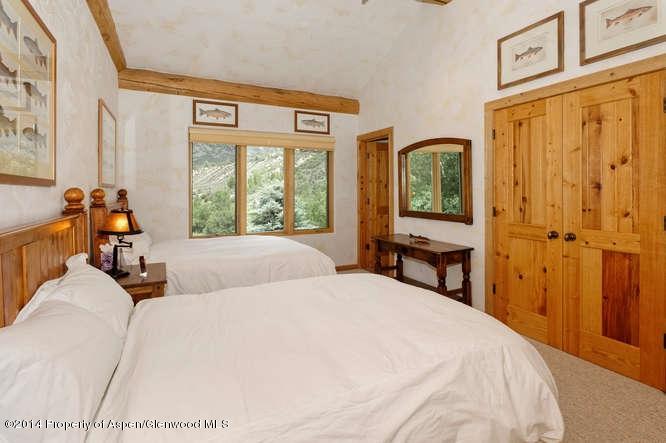 3768 Snowmass Creek Road Snowmass, CO 81654 - Photo 24 of 28 a bedroom with a bed a table and large windows