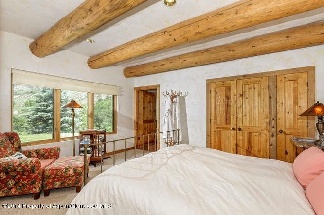 3768 Snowmass Creek Road Snowmass, CO 81654 - Photo 26 of 28 a bedroom with bed and large windows