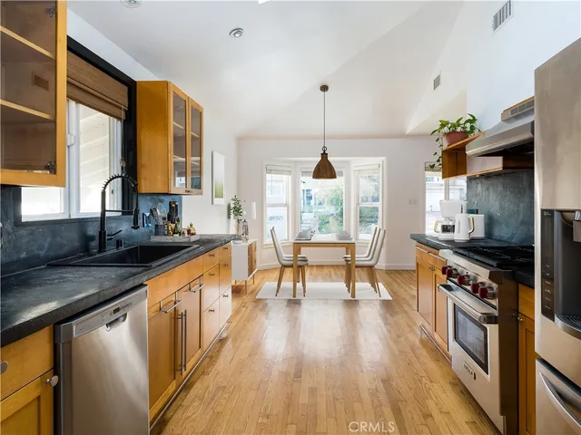 a kitchen with stainless steel appliances granite countertop wooden floors stove and sink