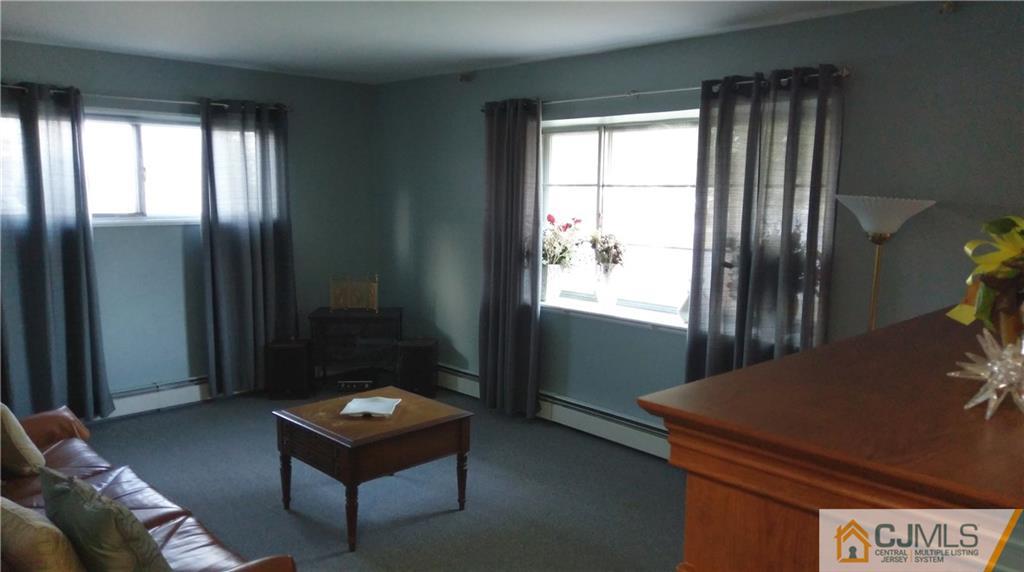 41 Winthrop Road Edison, NJ 08817 - Photo 9 of 18 a living room with a couch and a dresser next to a window